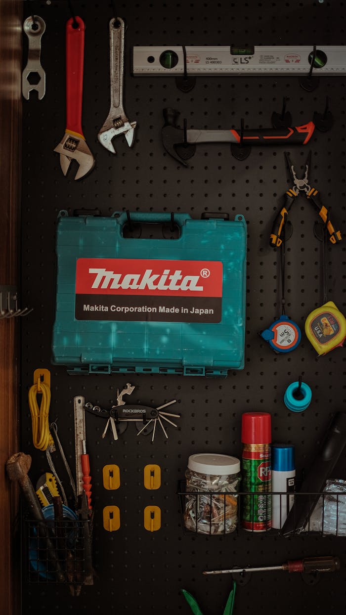 Neatly arranged tools on pegboard wall with a Makita toolbox in focus.